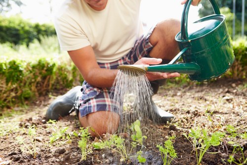 Insured gardeners preparing hedge trimming equipment in Pinner